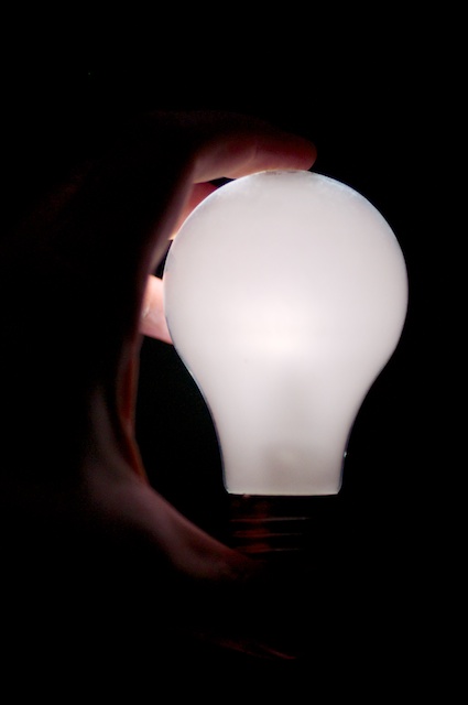 Light Bulb, lit, in a hand