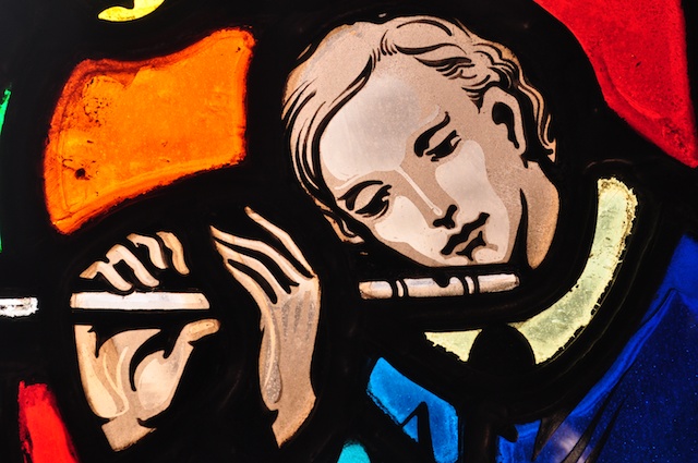 Stained Glass portait of Stephen Foster, playing a flute, close-up