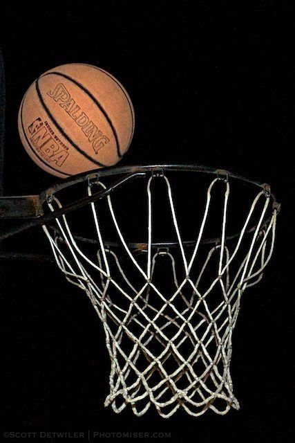 Basketball over the basket in the dark